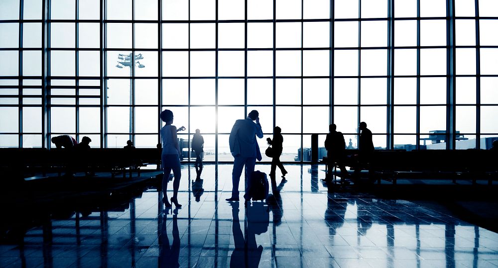Silhouettes Of Multi-Ethnic Group Of Business People Waiting In An Airport Terminal