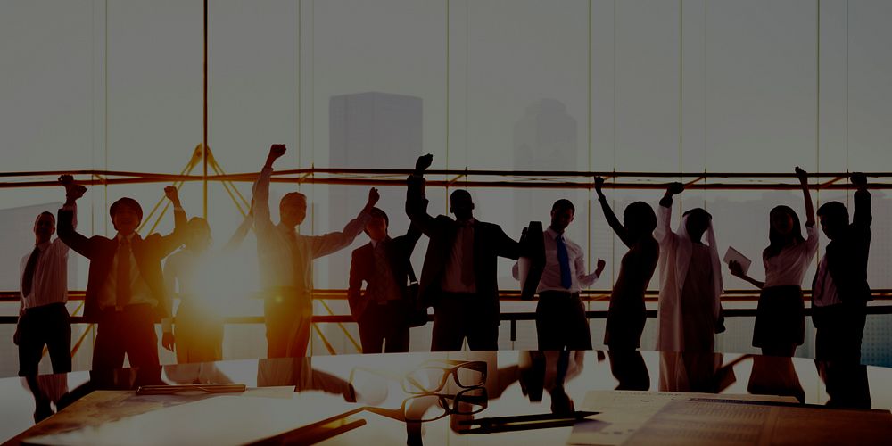 Group Of Business People Arms Raised In Board Room Concept