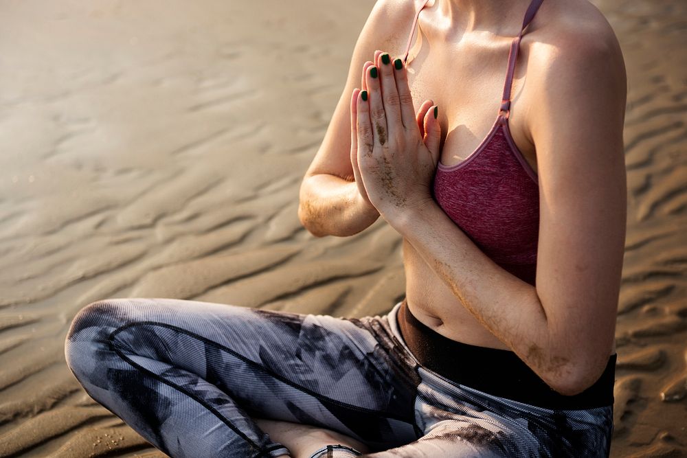 A woman is stretching at the beach