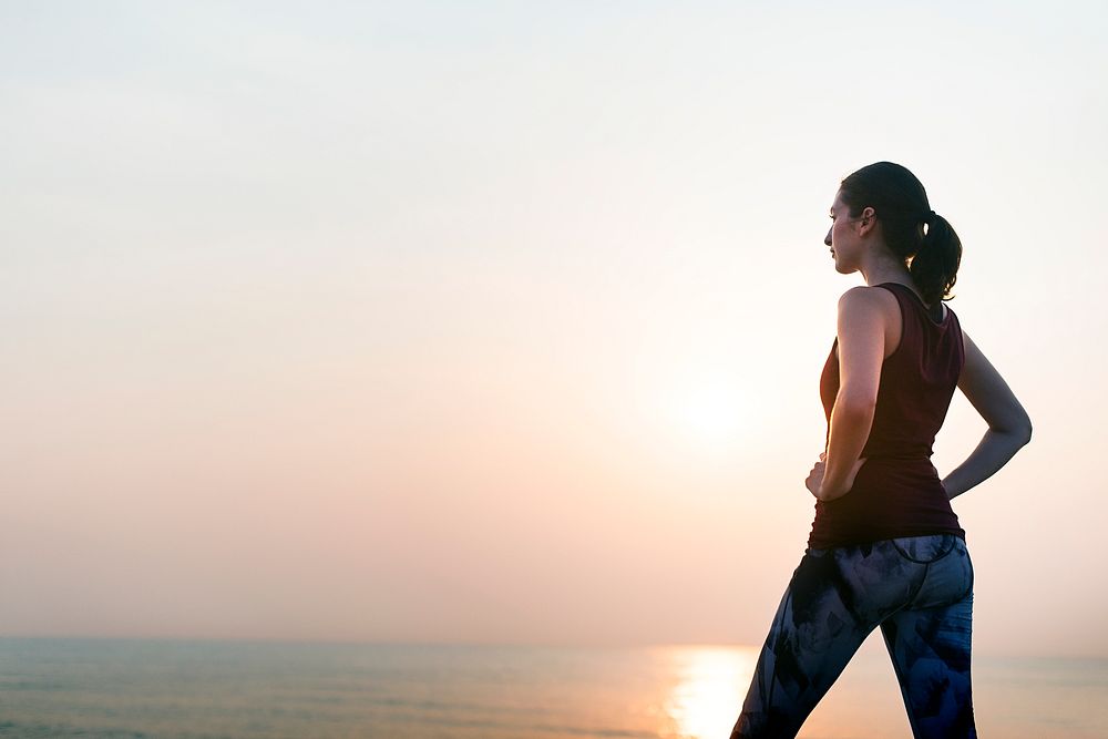 Young woman taking in a fresh breath by the beach after a work out