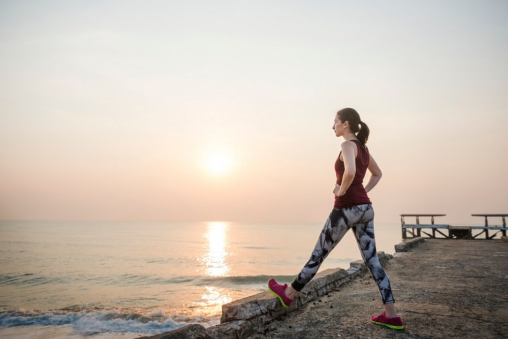 A woman is stretching at the beach