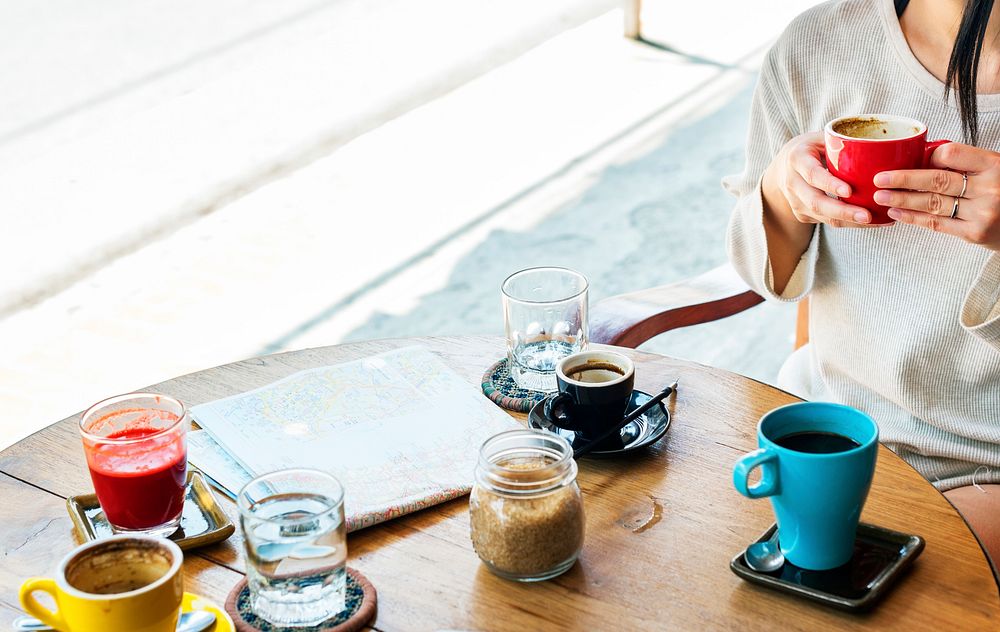 Woman sitting in coffee cafe with map on wooden table