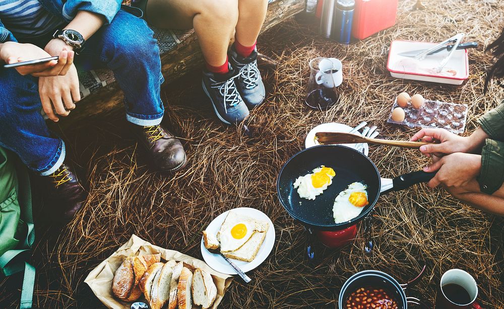 Group of friends camping together cooking food