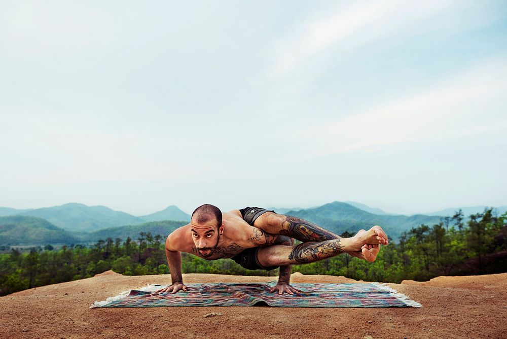 Man doing yoga on a cliff