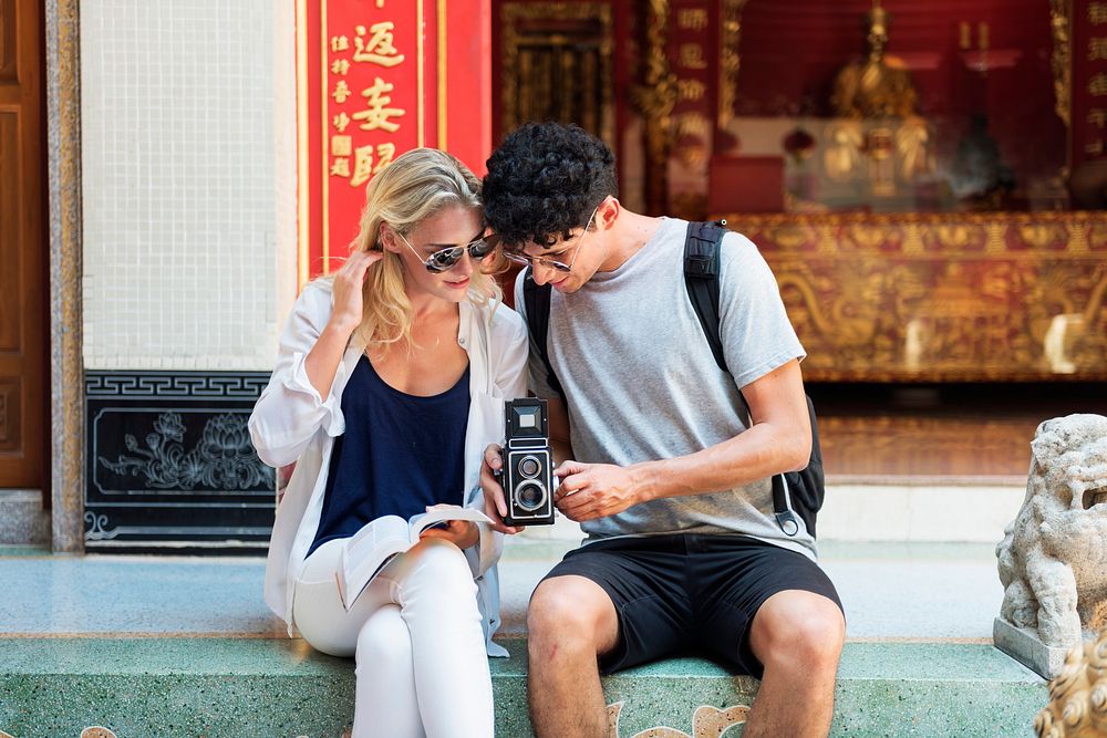 Couple with an analog camera outside a temple in Bangkok, Thailand