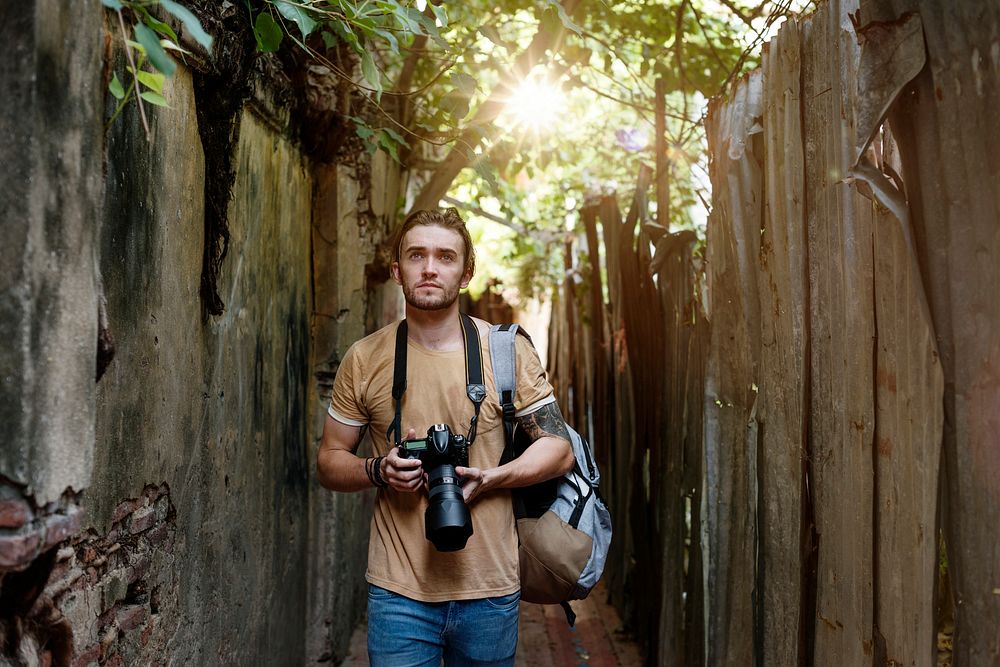 Caucasian photographer is walking in the alley