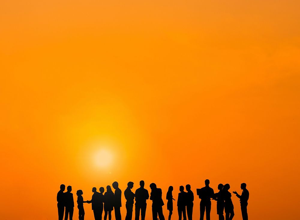 Silhouette of business people in a row communicating at sunset