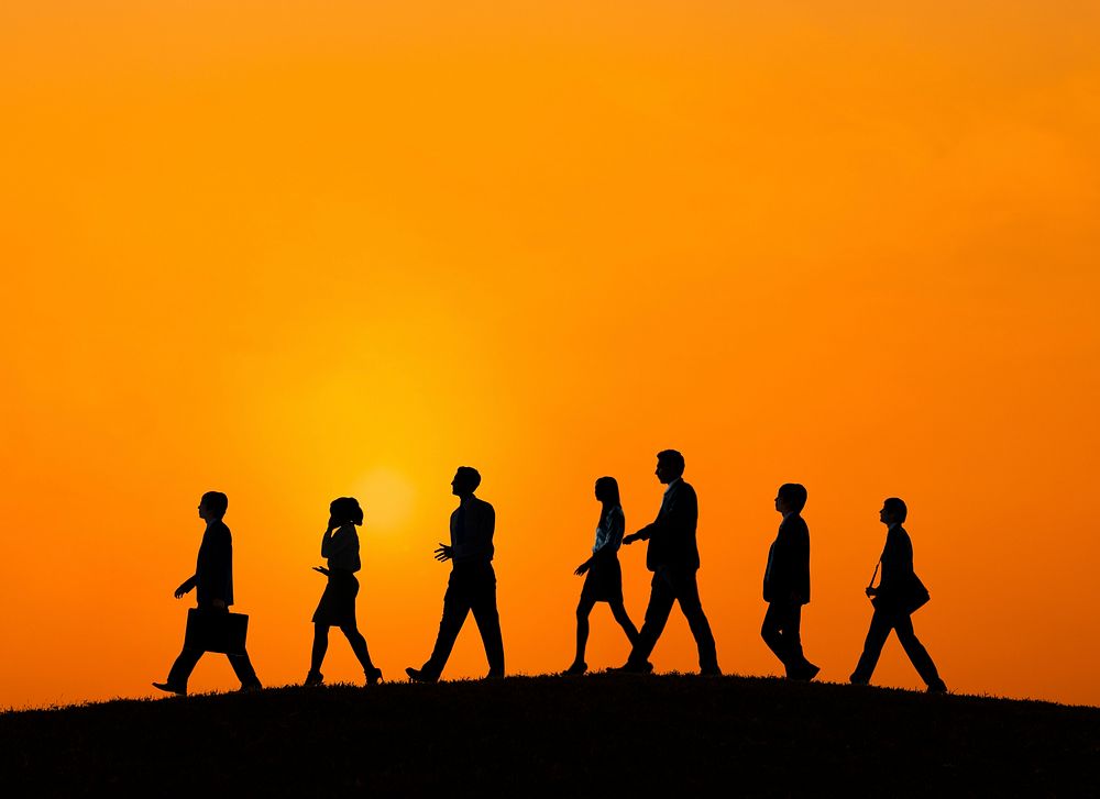Silhouette of business people walking at sunset