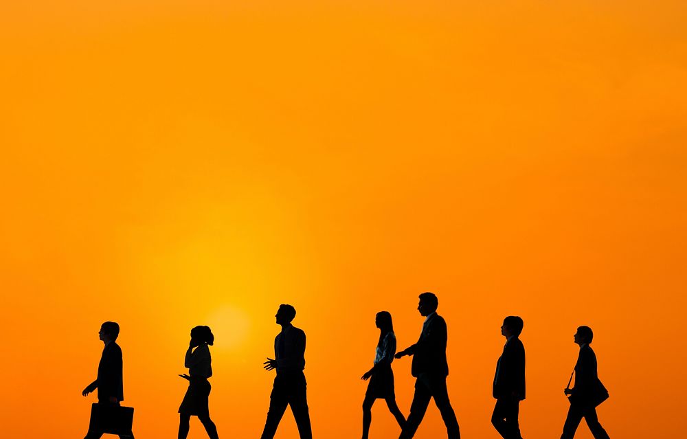 Silhouette of business people walking at sunset