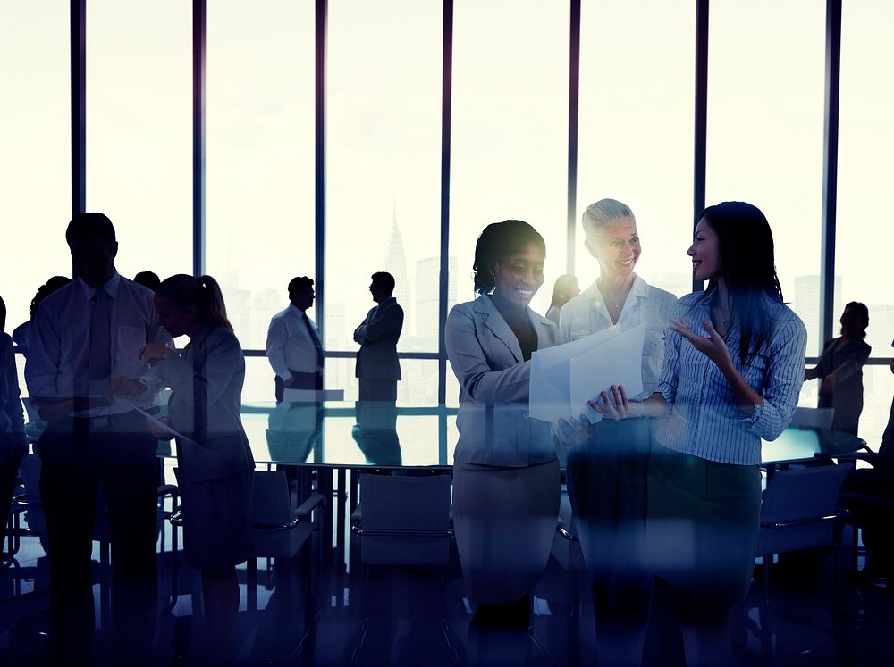 Silhouettes Of Multi-Ethnic Group Of Business People Working Together In A Board Room