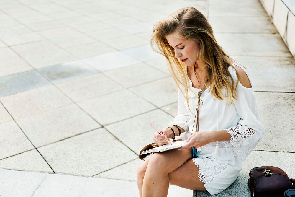 Caucasian woman sitting writing on notebook