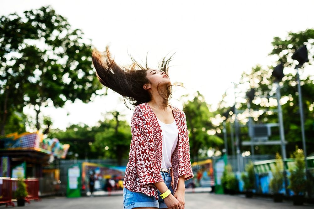 Young woman flinging her hair at an amusement park
