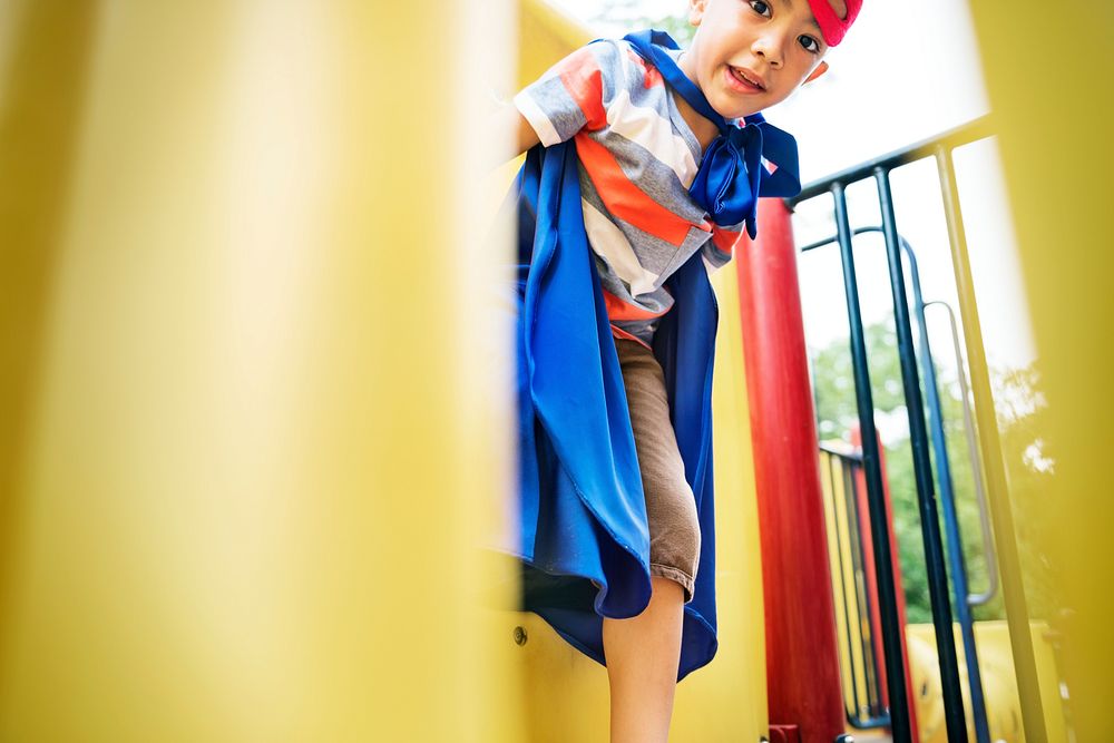 Little boy playing superhero at the playground