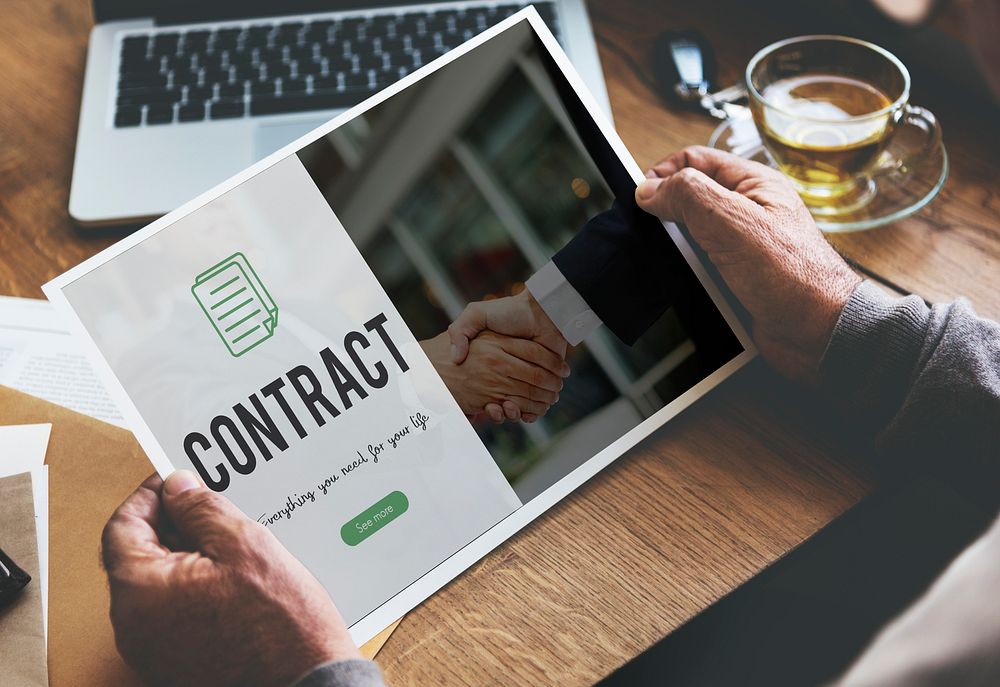Contract word on business handshake background
