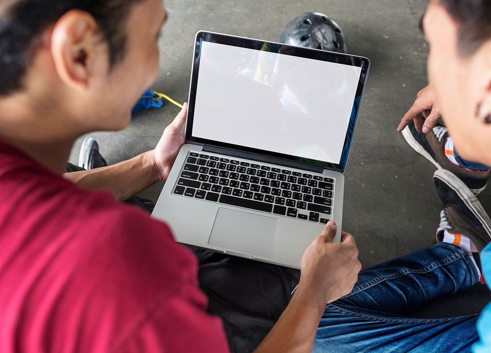 Young boys holding a computer mockup