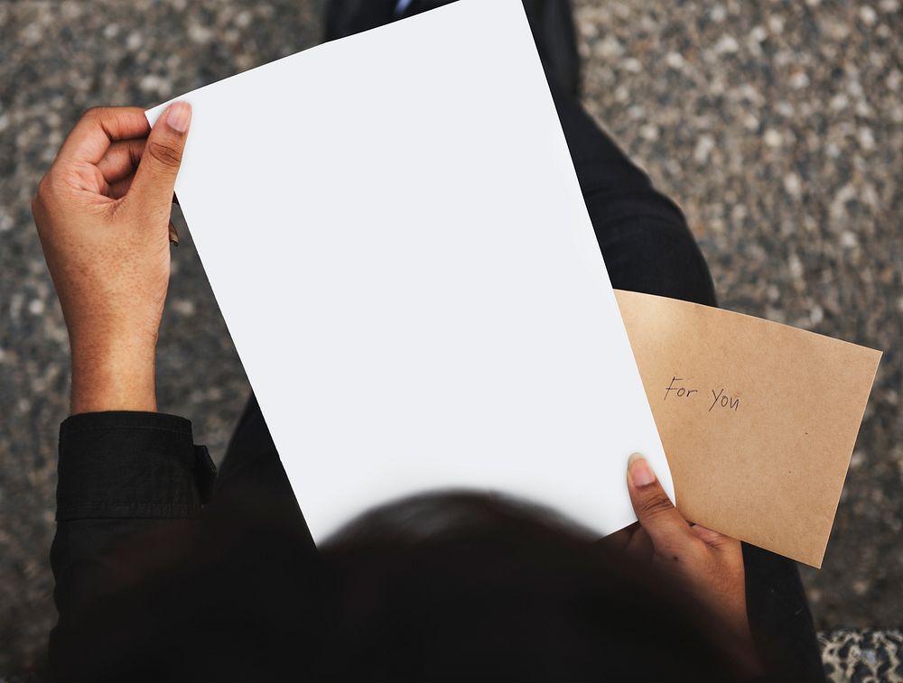 Holding a piece of blank paper mockup