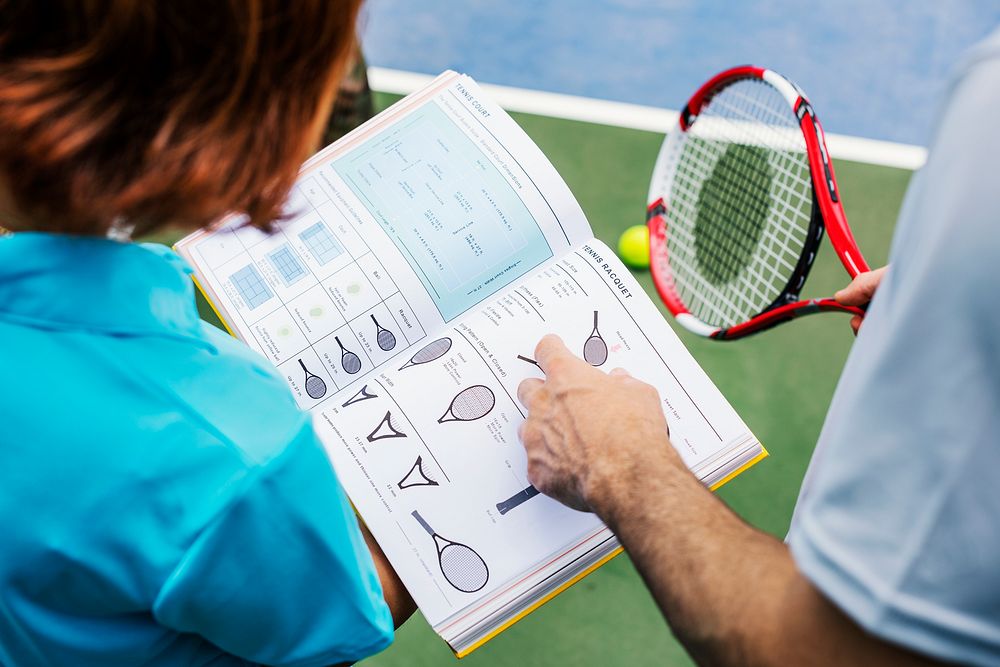 Tennis players reading manual