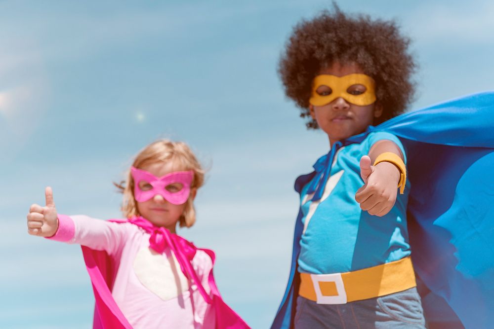 Boy with an afro and a blonde girl in superhero costumes