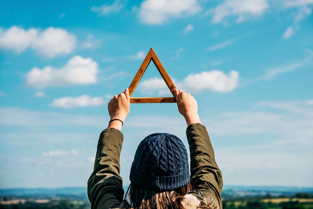 Closeup of hands holding wooden triangle frame