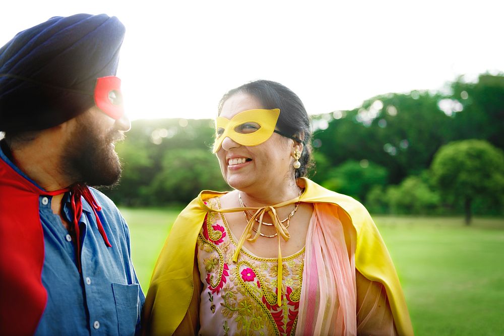 Loving senior Indian couple playing superheroes in the park