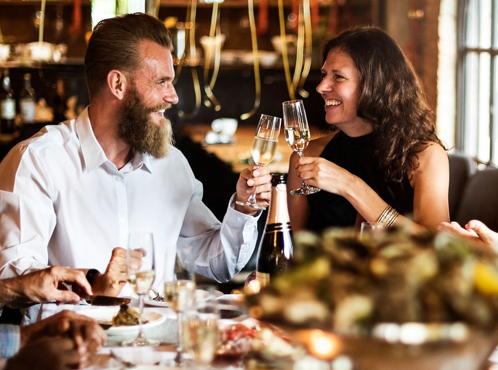 Caucasian couple clinking glasses together at restaurant
