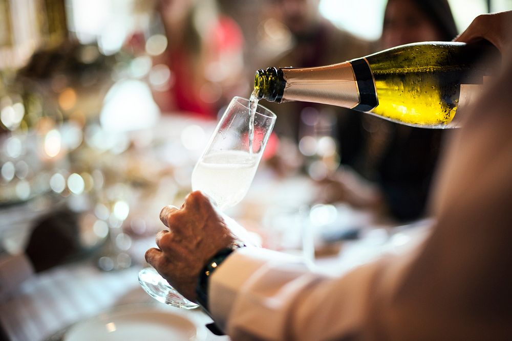 A waiter pouring sparkling champagne