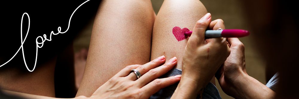 Woman drawing a heart on her thighs