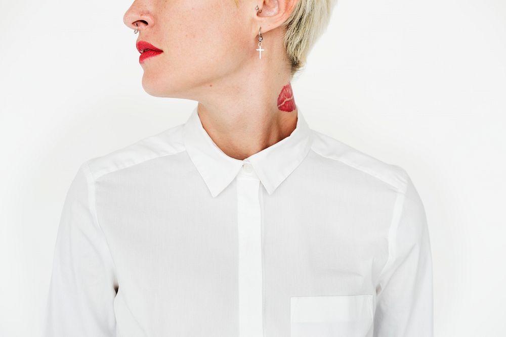 A blonde short-haired woman with tattoos in white shirt