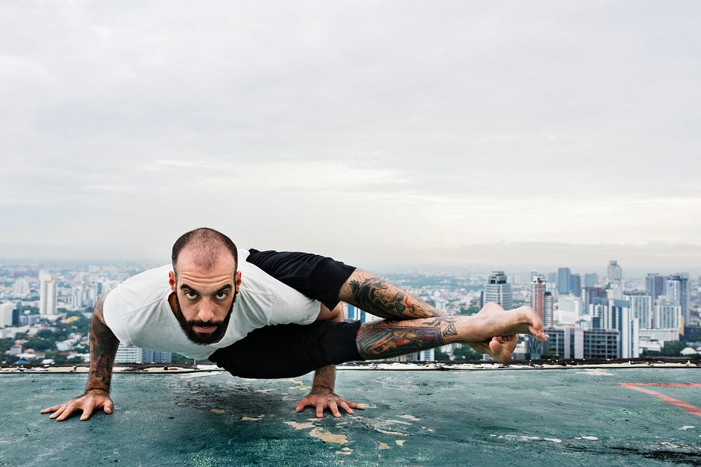 Man practicing yoga on a rooftop