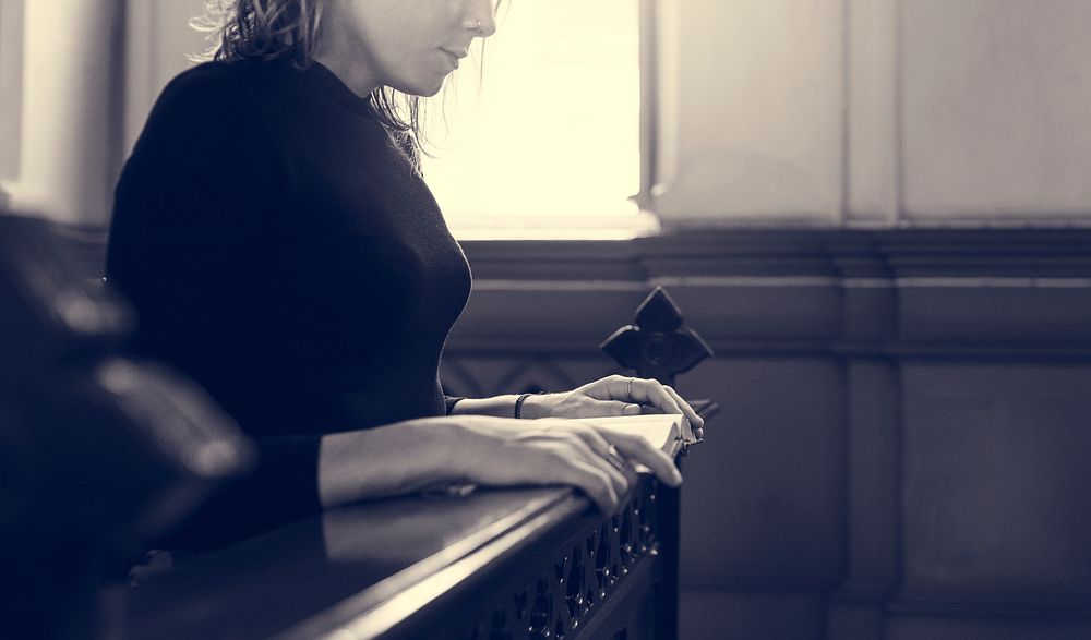 Woman praying in the church grayscale