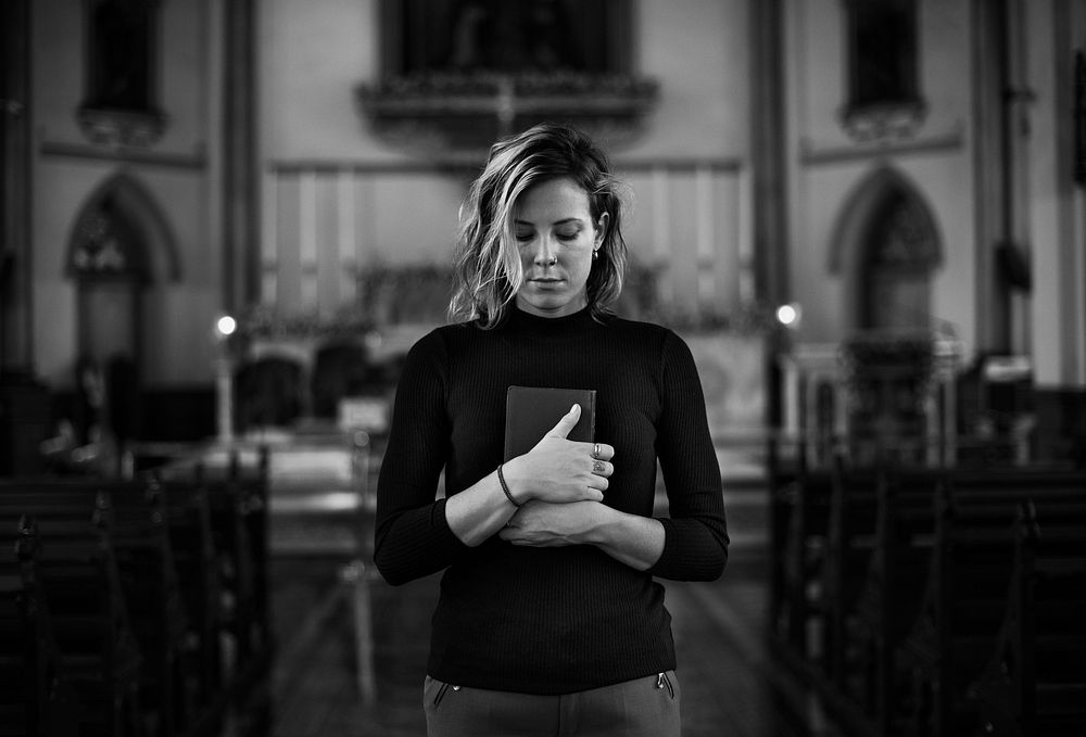 Woman praying in the church grayscale