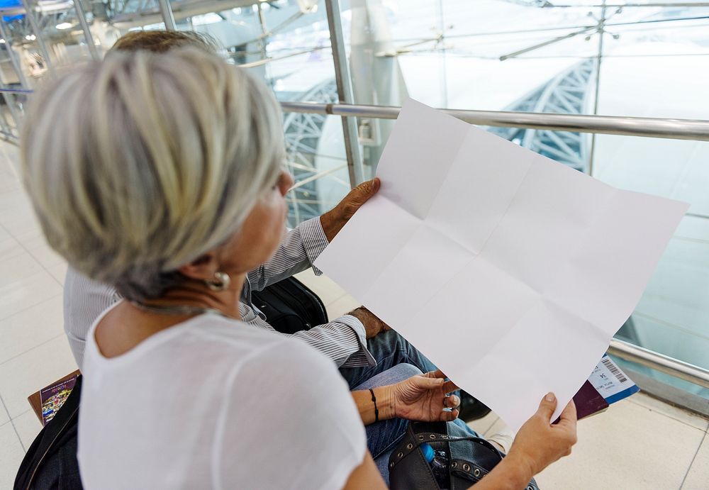 Senior couple looking at blank paper airport