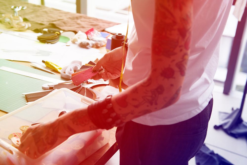 Fashion designer tattooed girl choosing material