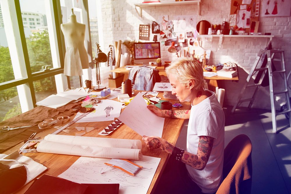 Fashion designer tattooed girl on her workspace