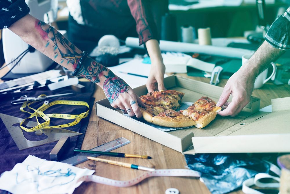 Group of fashion designer have pizza for lunch