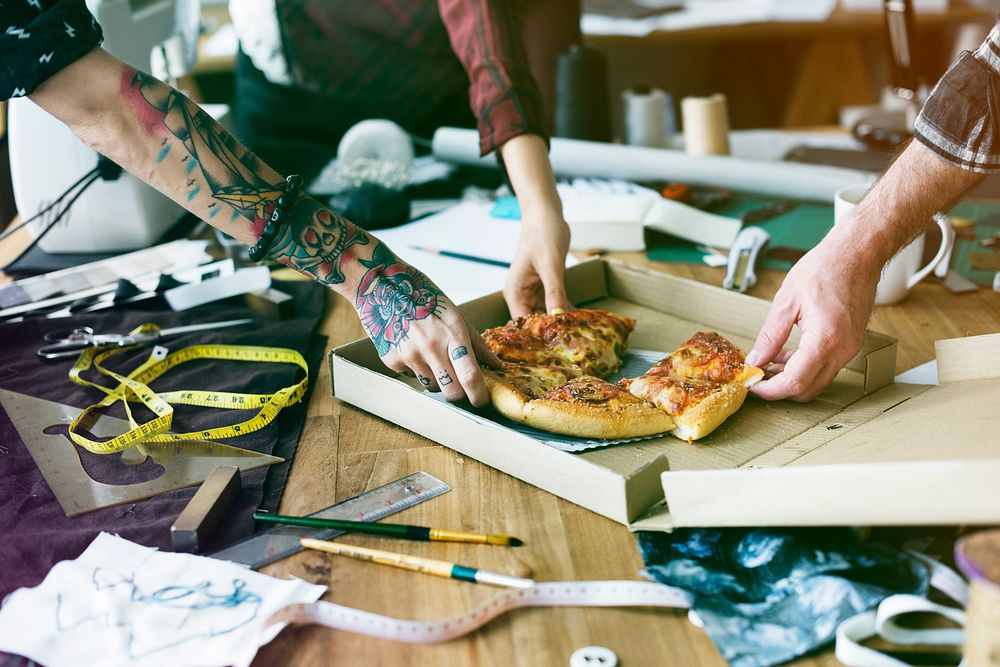 Group of fashion designer have pizza for lunch