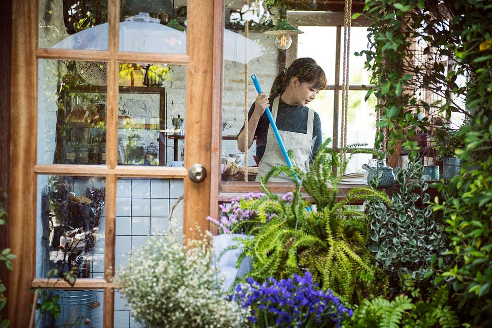 Woman cleaning up inside her flower shop