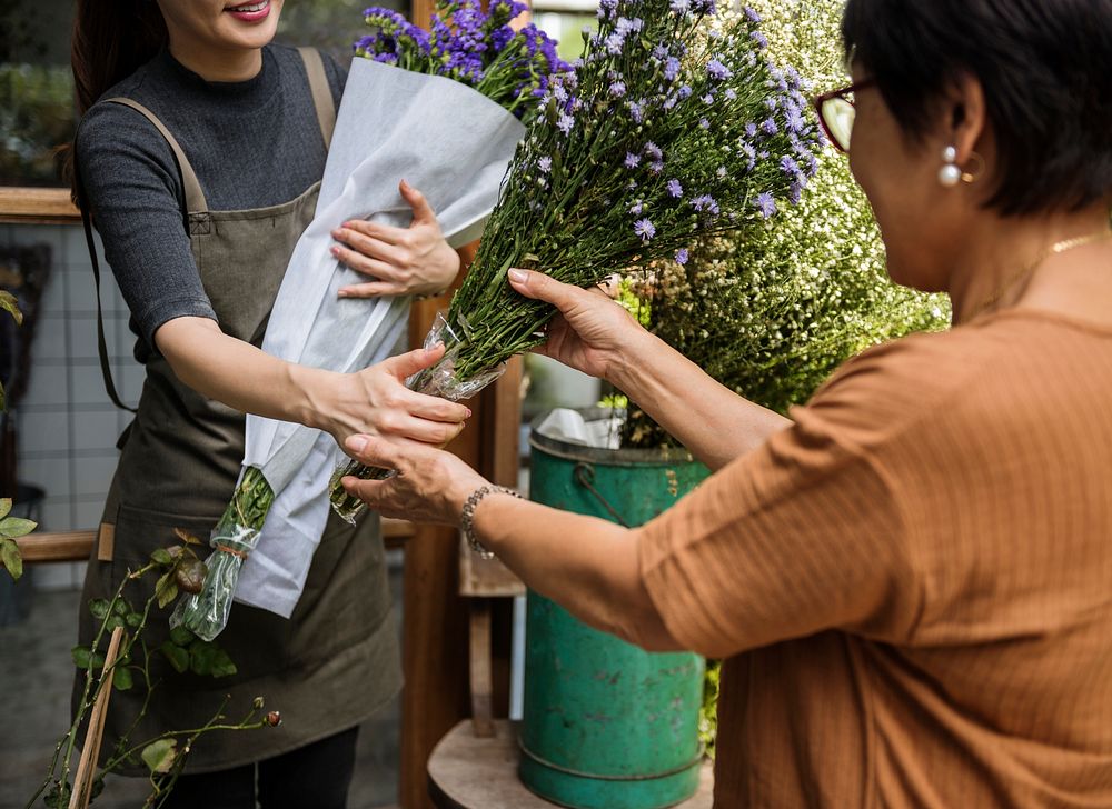 Woman selling flowers to her customer
