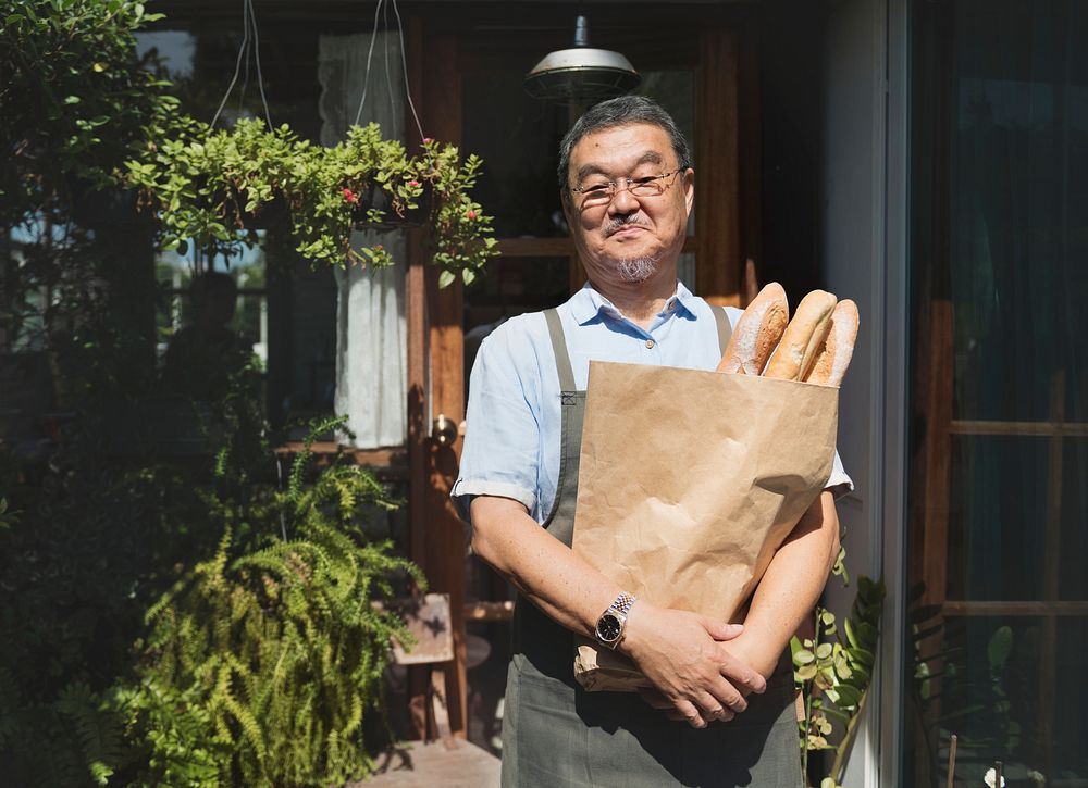 A man holding a bag of bread