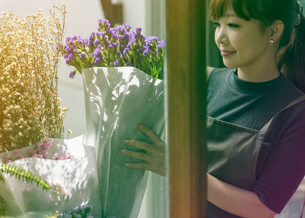 Young florist woman decorating flower bouquet