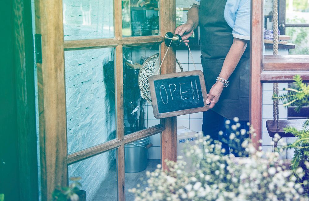 Man flip the open banner of cafe at the door