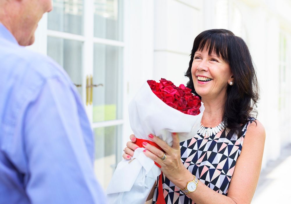 Senior woman holding bouquet of roses given by her lover
