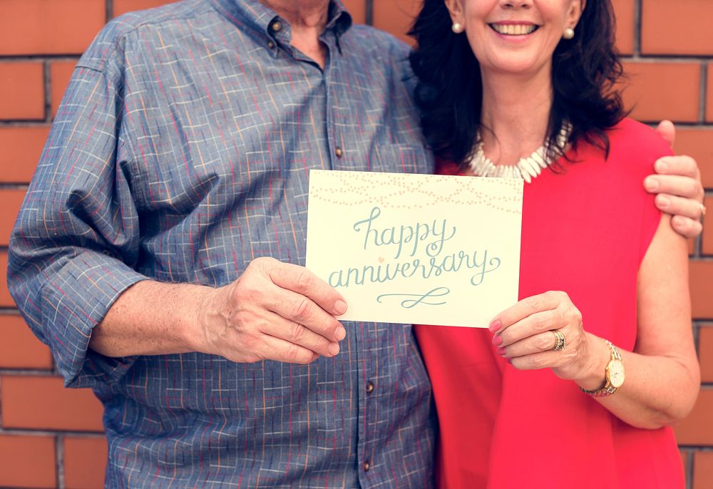 Couple holding a happy anniversary card