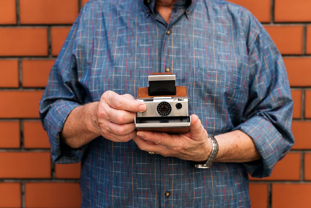 Guy holding a retro instant camera