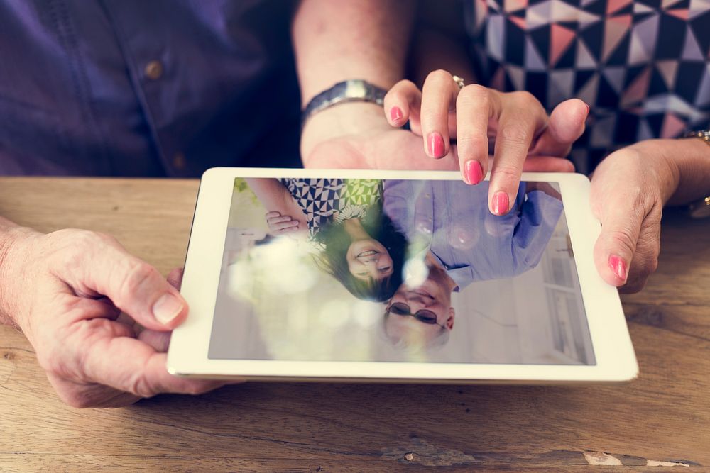 Man woman looking at their photo on tablet