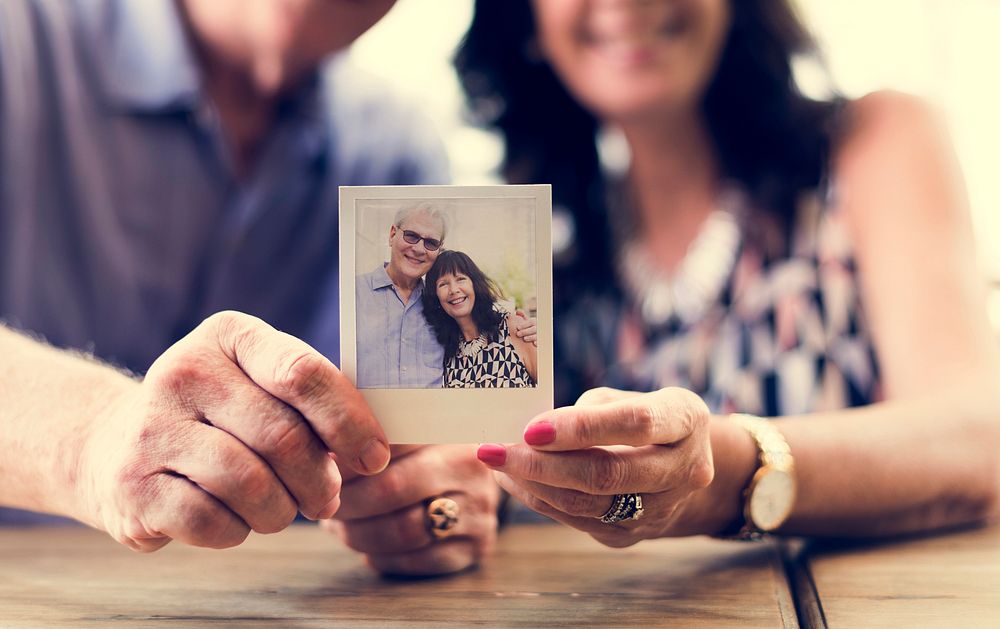 Close up couple showing instant camera image