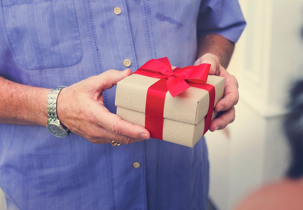 Guy holding a box of present with red bow