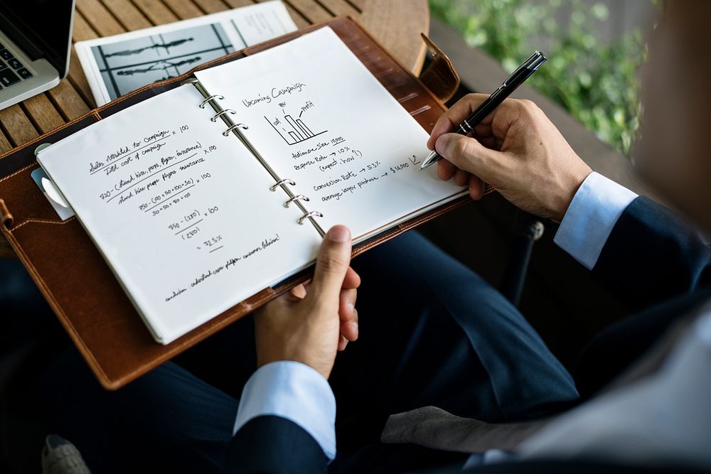 Businessman writing a business plan on a notebook