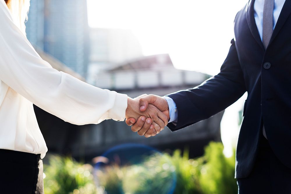 A closeup of businessman and businesswoman shaking hands in an agreement