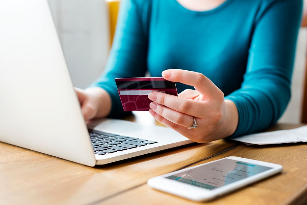 Woman holding a credit card and working on her laptop